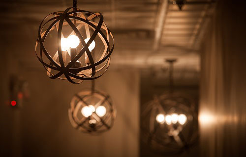 Woven metal orb pendants glowing along the hallway